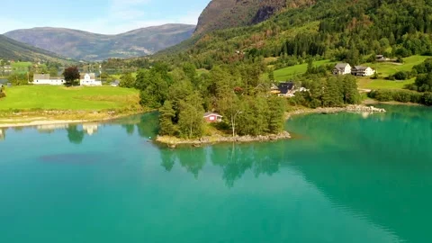 House hidden between trees surrounded by beautiful lake and landscape - Fly away Stock Footage 166952692