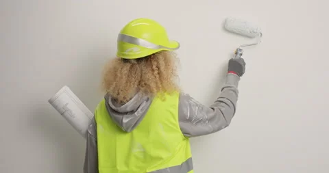 House improvement. Curly haired young woman construction worker wears helmet and Stock Footage 155862610