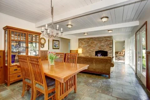 House interior with open floor plan. Dining room with wooden furniture set, l Stock Photos