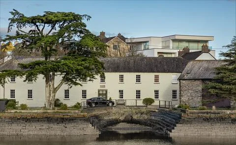 House with its own tiny harbour and a tree in the garden viewed across the .. Stock Photos