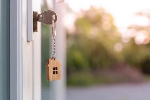 The house key is inserted in front of the door and opens to welcome the new o Stock Photos