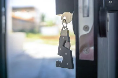 A house key with a key ring inserted at the door lock. Buy new home or concep Stock Photos