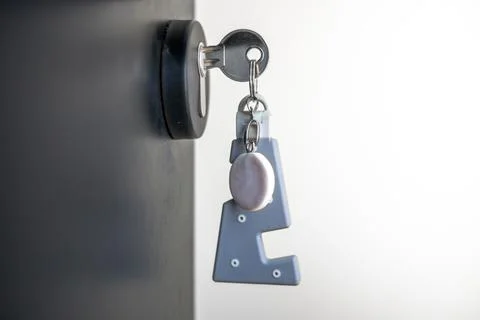 A house key with a key ring inserted at the door lock. Buy new home or concep Stock Photos