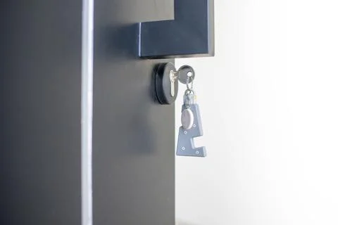 A house key with a key ring inserted at the door lock. Buy new home or concep Stock Photos