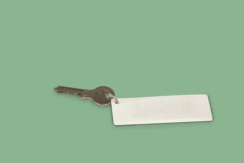 The house key with a tag on light green background Stock Photos