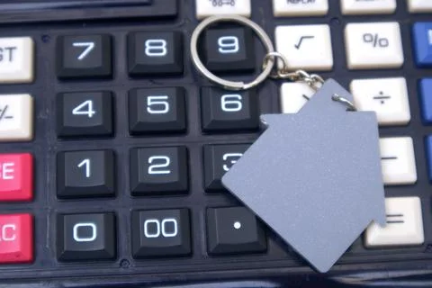 House key on top of calculator Stock Photos