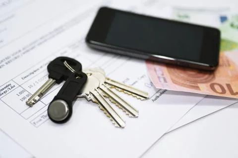 House keys on documents with mobile phone Stock Photos