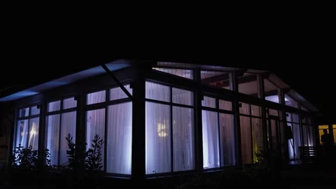 In house with large windows color light blinks and changes at night. Stock Footage 220524277