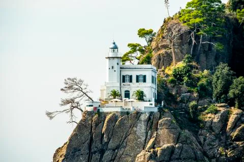 House with lighthouse on rock Stock Photos