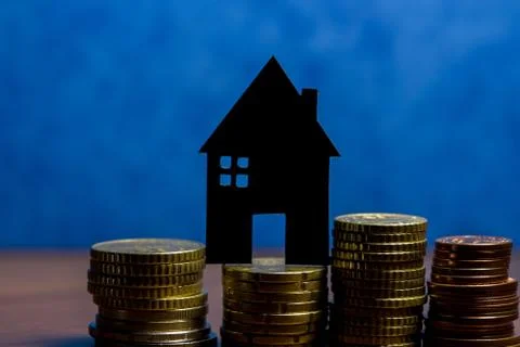 A house made of blackboard and a stack of euro coins in a blue background Stock Photos