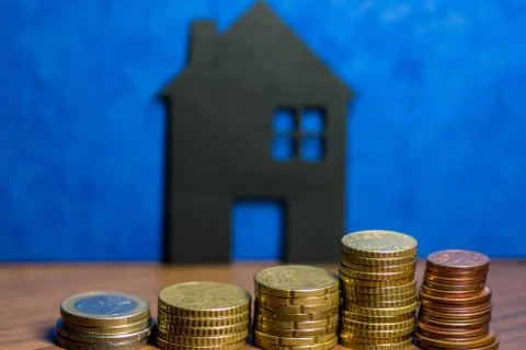 A house made of blackboard and a stack of euro coins in a blue background Stock Photos