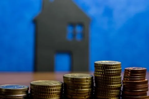 A house made of blackboard and a stack of euro coins in a blue background Stock Photos