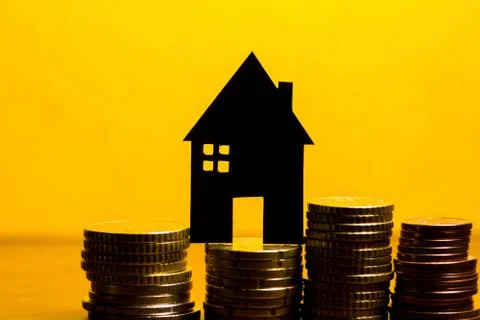 A house made of blackboard and a stack of euro coins in a yellow background Stock Photos