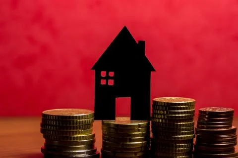 A house made of blackboard and a stack of euro coins in a red background Stock Photos