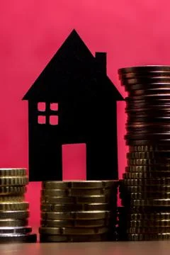 A house made of blackboard and a stack of euro coins in a red background Stock Photos