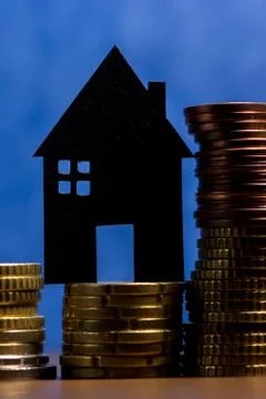 A house made of blackboard and a stack of euro coins in a blue background Stock Photos