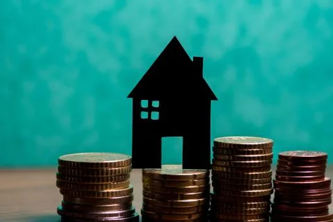 A house made of blackboard and a stack of euro coins in a green background Stock Photos