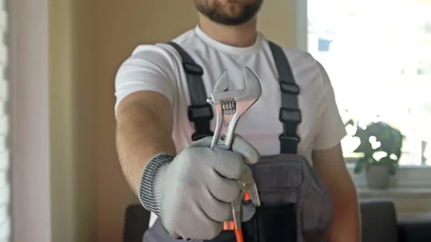 House master. Young strong man in overalls with a adjustable wrench in his hands Stock Footage 167013406