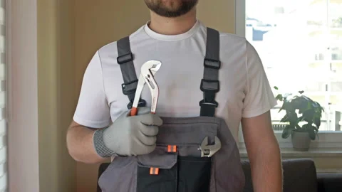 House master. Young strong man in overalls with a adjustable wrench in his hands Stock Footage 178368945