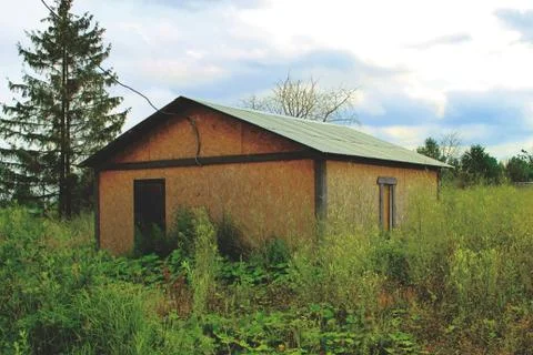House in the middle of the forest trees clouds green grass nature Stock Photos