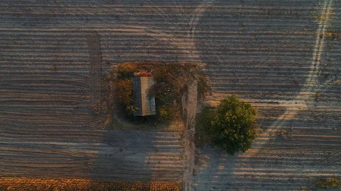 A house in the middle of plowed fields, filmed with a drone moving upwards. Stock Footage 114430801