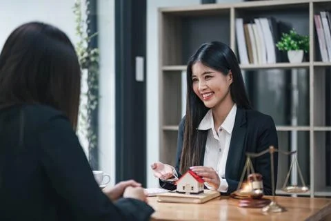 House model with agent and customer discussing for contract to buy, get Stock Photos