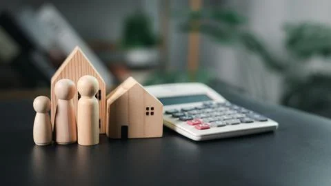 House model and the human next to the calculator emphasize real estate and .. Stock Photos