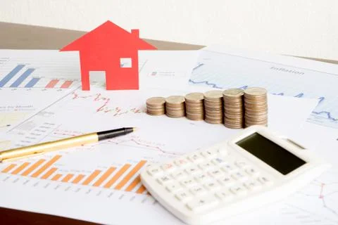 With House Model And Stack Of Coins On Desk Stock Photos