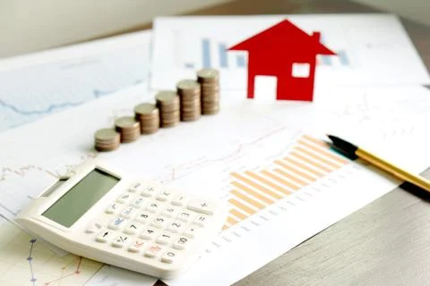 With House Model And Stack Of Coins On Desk Stock Photos