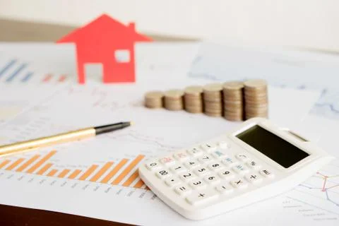 With House Model And Stack Of Coins On Desk Stock Photos
