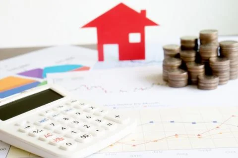 With House Model And Stack Of Coins On Desk Stock Photos