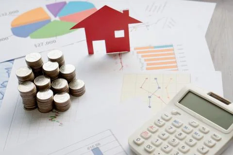 With House Model And Stack Of Coins On Desk Stock Photos