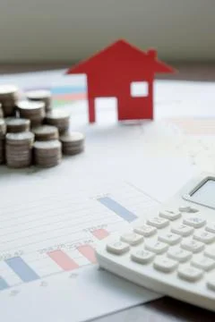 With House Model And Stack Of Coins On Desk Stock Photos