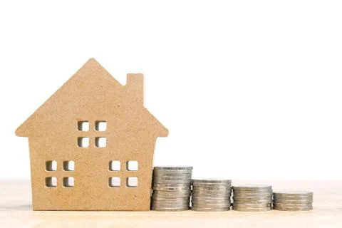 House model and stack of coins on table Stock Photos