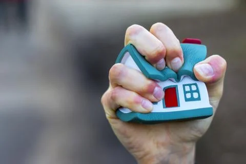 House model being squeezed in woman's hand. Stock Photos