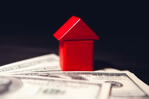 House model with dollar banknotes and red house model on wooden floor with .. Stock Photos