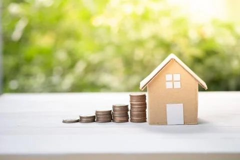 House model with increase of graph coins stacking on greenery soft focus. Stock Photos