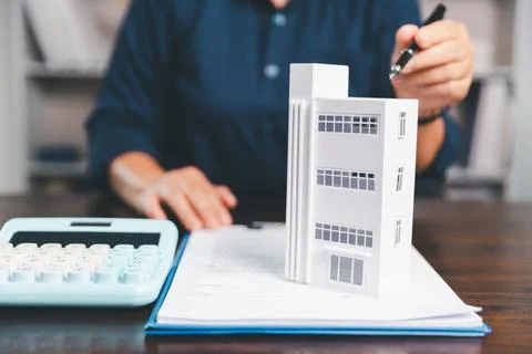 House model placed on table alongside coins, paperwork symbolizes real esta.. Stock Photos