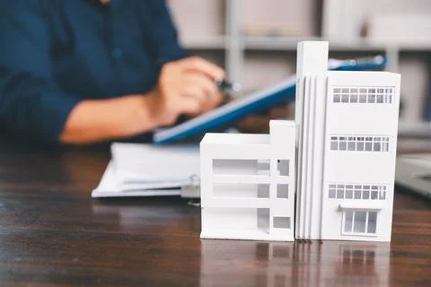 House model placed on table alongside coins, paperwork symbolizes real esta.. Stock Photos