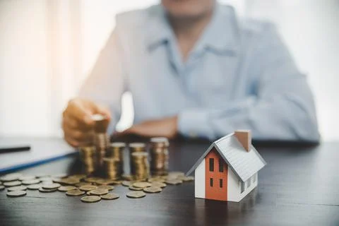 House model with stack coins, business hand is planning savings money of coin Stock Photos