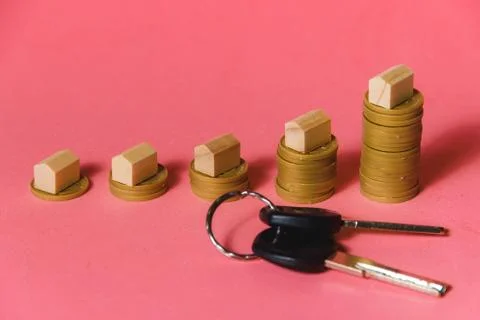 House Models On Top Of Increasing Stacked Coins Over Pink Background. Mortgage Stock Photos