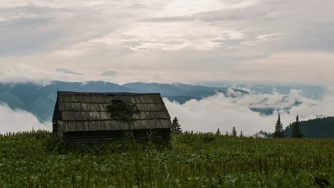 A house in the mountains, clouds float above the mountains Stock Footage