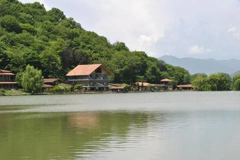 House on the mountainside and by the lake surrounded by forest Stock Photos