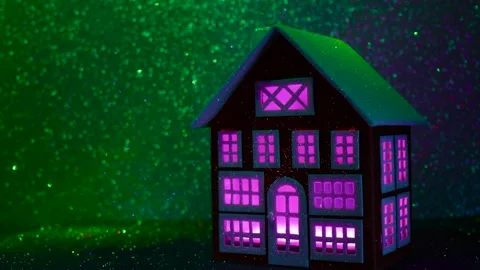 A house with multi-colored glowing windows on a background that changes colors Stock Footage 265006086