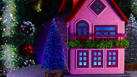 House with multi-colored lighting in the windows surrounded by Christmas trees Stock Footage 283526123
