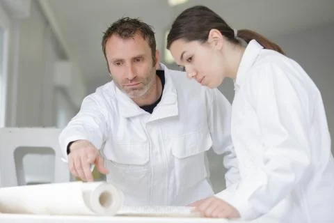 House painter and apprentice paint a wall Foto stock