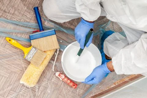 House painter at work prepares white paint Stock Photos