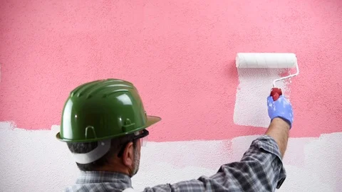 House painter worker painting the pink wall with white paint. Building. Stock Footage 106280448