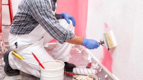 House painter worker at work in the construction site. Building. Stock Photos