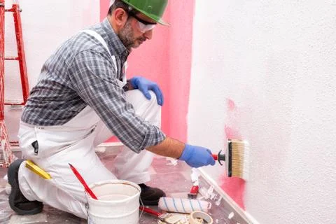 House painter worker at work in the construction site. Building. Stock Photos